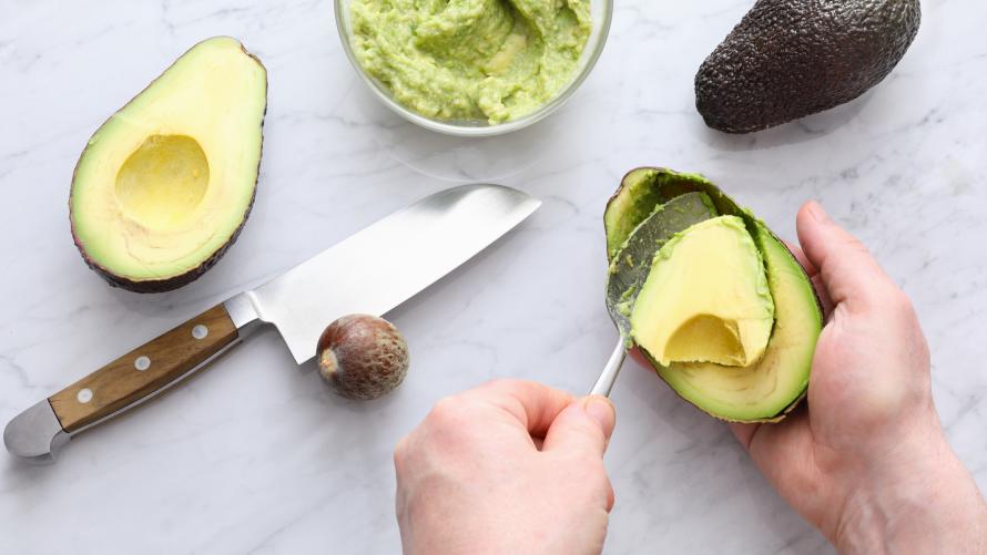 Fruchtfleisch mit Löffel aus der Avocado heben