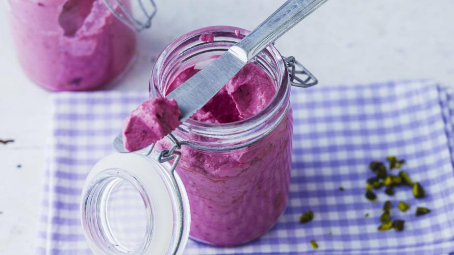 Brombeer-Frischkäse-Aufstrich in kleinen Gläsern mit Brotmesser.
