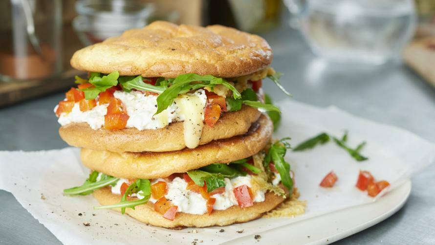 Cloud Bread Sandwich mit Rucola und Tomate auf einem Teller
