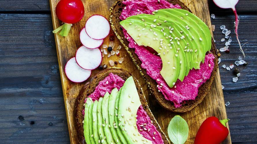 Zwei Brote mit Rote Bete und Avocado auf Brett