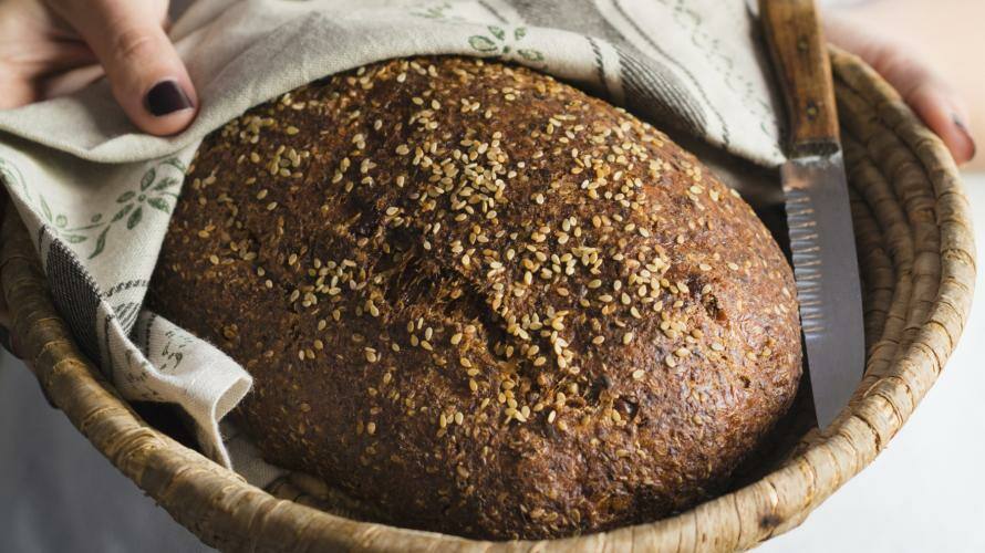 Frau hält Korb mit Brot in die Kamera