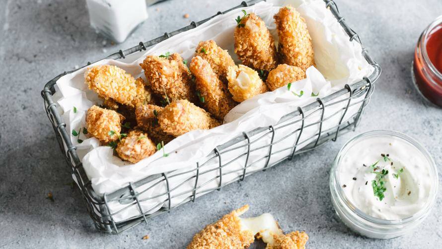 Mozzarella Sticks in einem Metallkörbchen mit Kräuterdip