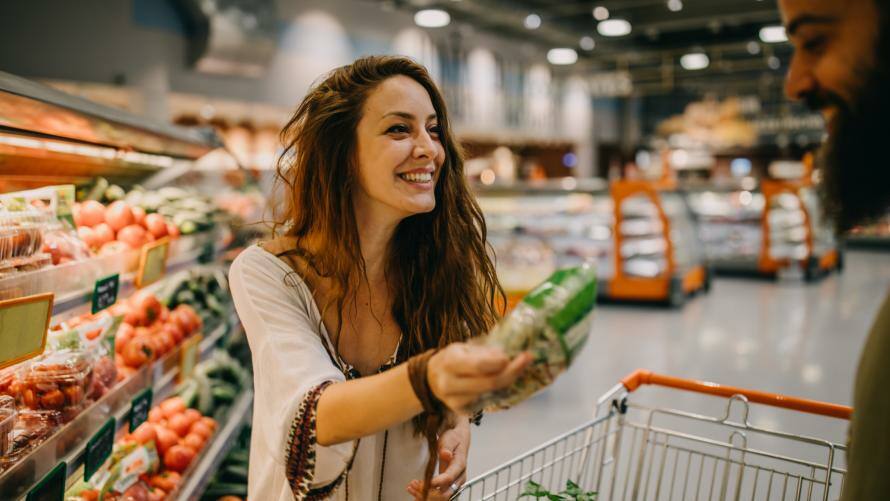 Frau zeigt Mann im Supermarkt ein Produkt