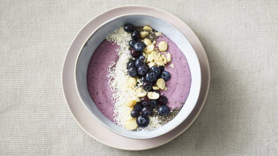 Smoothie-Bowl in einer Schüssel, die auf einem Teller serviert wird