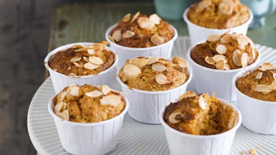 8 Muffins in weißen Förmchen auf rundem Tablett