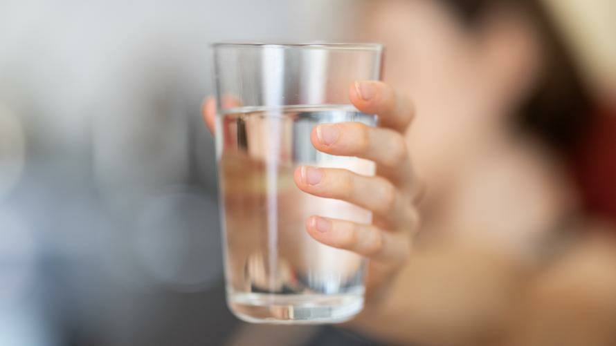 Wasserglas in einer Hand