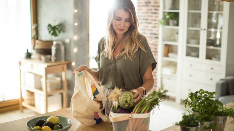 Frau sortiert auf dem Küchentisch besonnen ihre Einkäufe