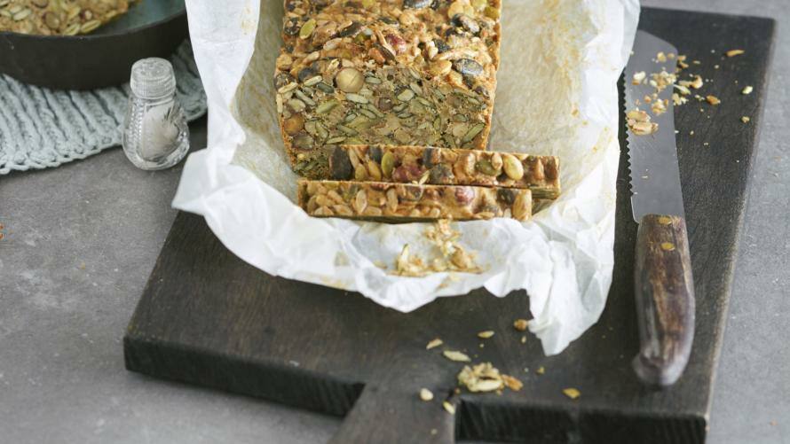 Nussbrot in Backpappier auf Brett mit Messer