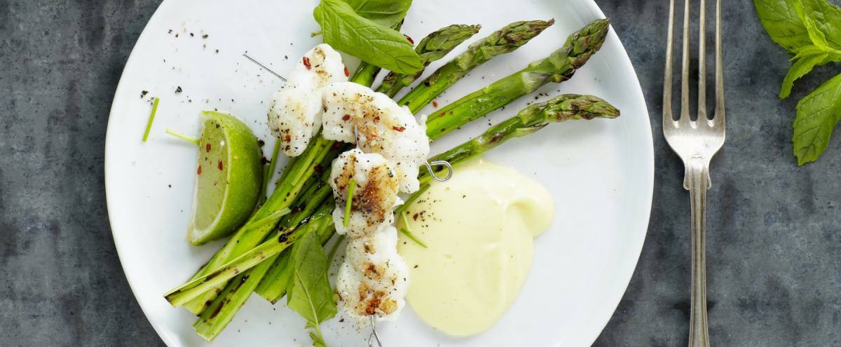 Teller mit Spargel und Fischspiessen Limetten und Minze
