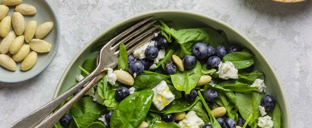 Teller mit Babyspinat, Blaubeeren, Mandeln, Feta und klarem Dressing
