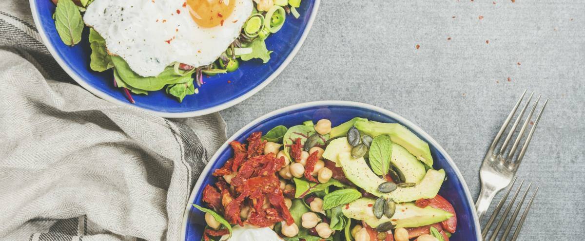 Gemüse und Spiegeleier in blauen Schalen