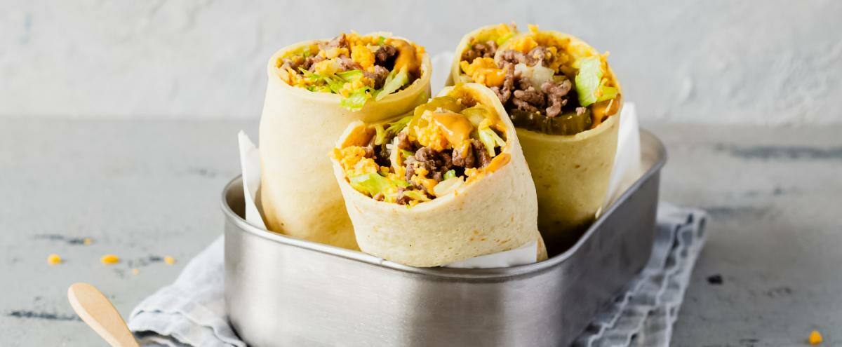 3 kleine Wraps mit Hack und Cheddar, deneben Schälchen mit Sauce