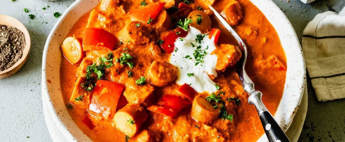 Low-Carb-Wurstgulach auf einem tiefen Teller angerichtet