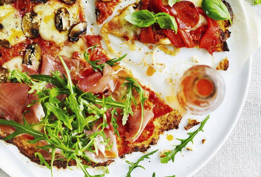 Blumenkohl-Pizza mit Schinken, Champignons und Rucola