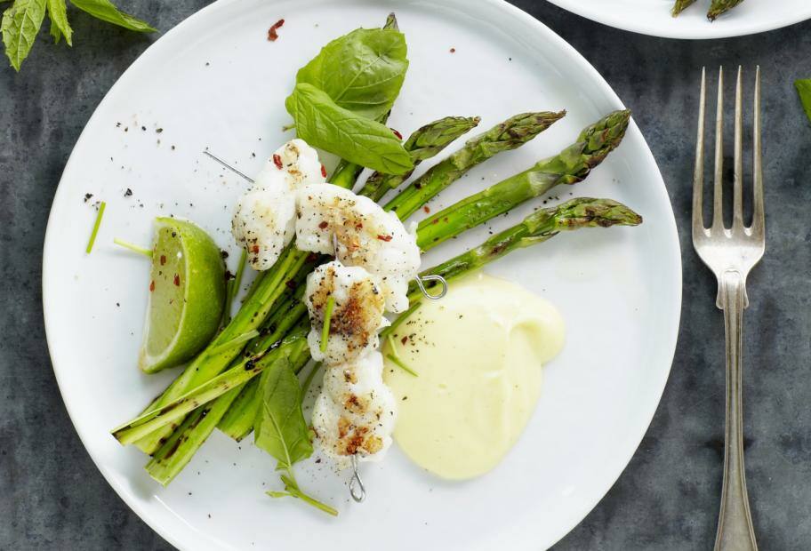 Fischspieße auf grünem Spargel mit Limettensauce