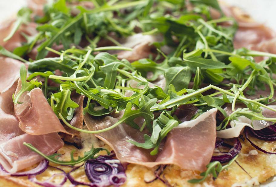 Flammkuchen mit Käseboden, Schinken und Rucola