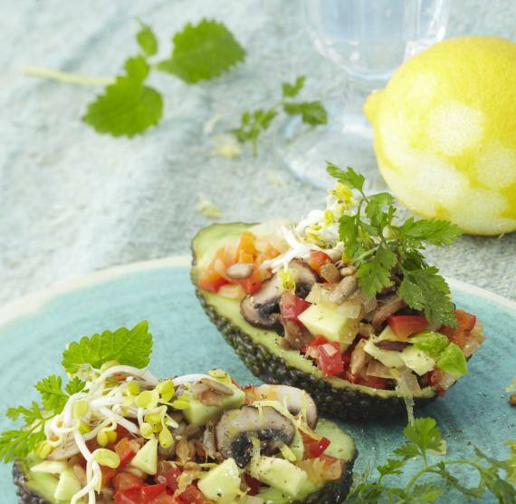 Teller mit 2 Avocadohälften, gefüllt mit Pilzen und Salat