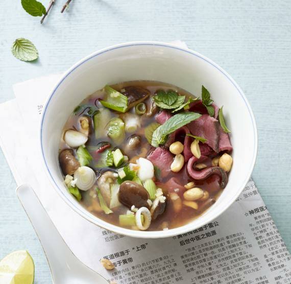 Schüssel mit Brühe und asiatischen Einlagen