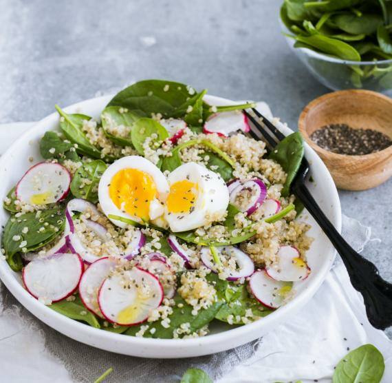 Quinoa-Spinat-Salat mit Chiasamen und Ei auf einem Teller