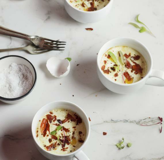 Gebackene Eier mit Parmesan und Schinken in kleinen weißen Tassen