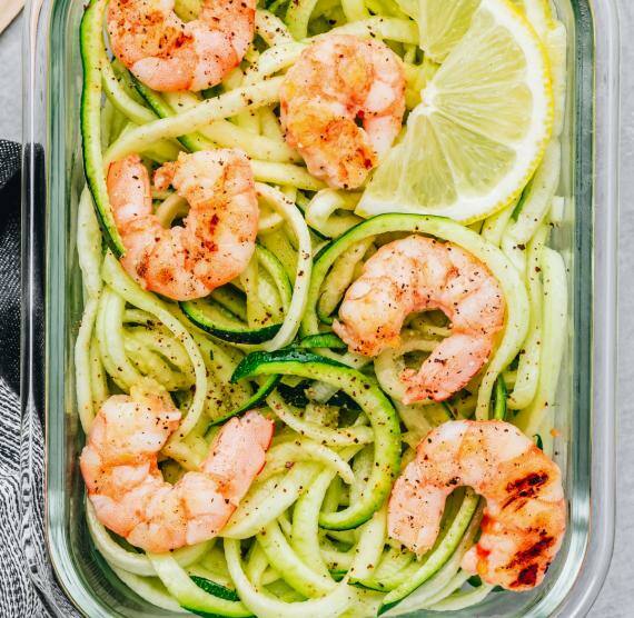 Zucchinistreifen und Garnelen in einer Glasform