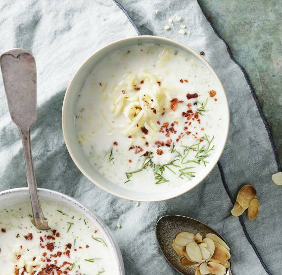 Schalen und Topf mit Suppe und Mandeln