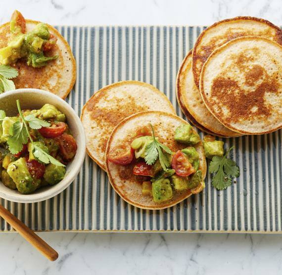 Pancakes mit Avocado-Salsa auf einem Brett