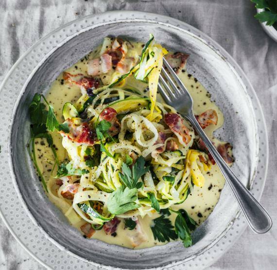 Gemüse-Nudeln alla Carbonara in einem grauen Teller mit einer Gabel