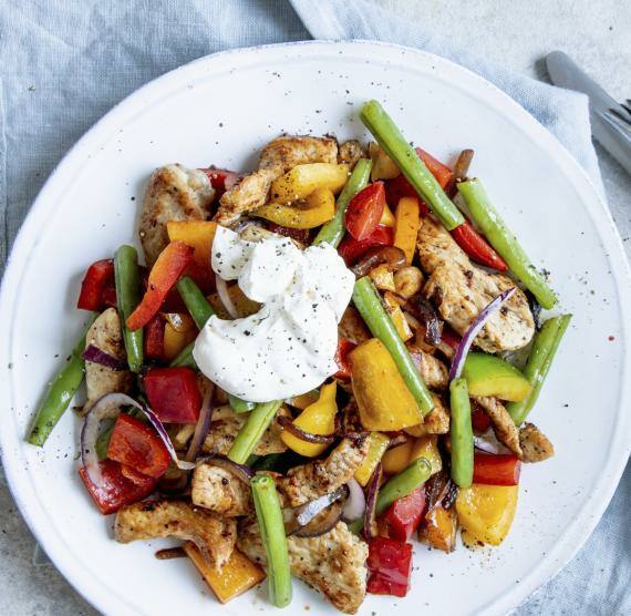 Teller mit Gemüse und Fleisch auf blauer Serviette