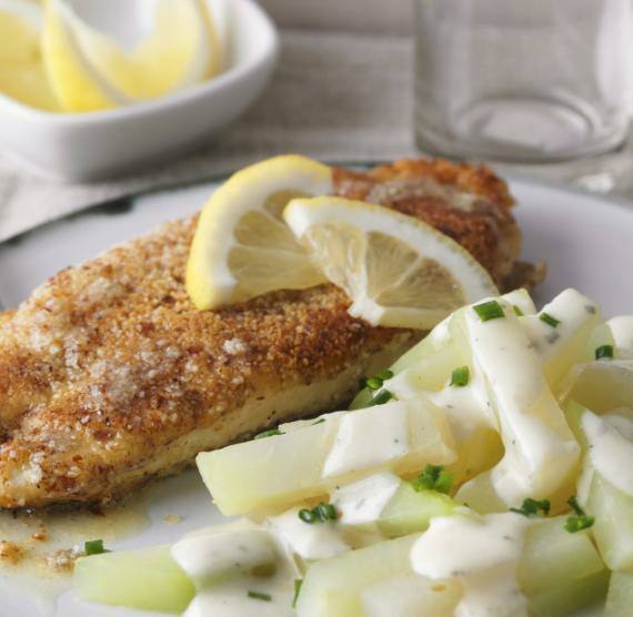 Schnitzel und Kohlrabi auf einem Teller mit Gabel und Zitronen