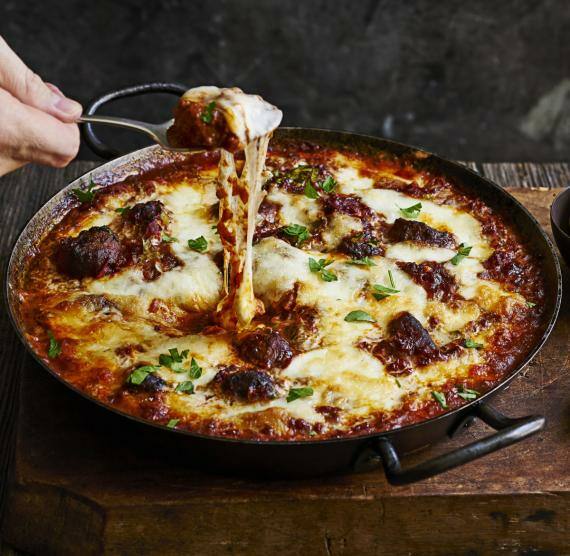 Pfanne mit Fleischbellchen in Tomatensauce und Käse, Gewürzgurcken und Zwiebeln
