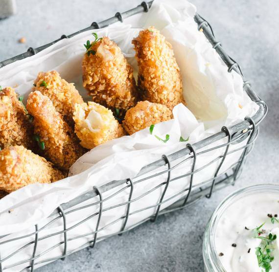 Mozzarella Sticks in einem Metallkörbchen mit Kräuterdip
