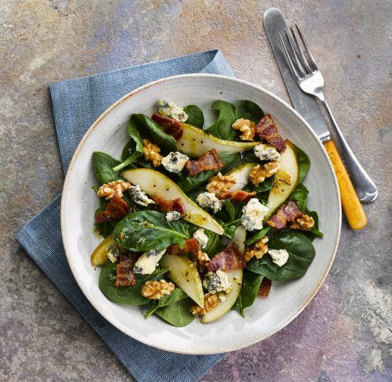 Teller mit Spinatsalat, Birnenspalten, Speck, Blauschimmelkäse und Walnüssen