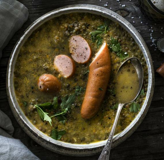 Topf mit Linsensuppe und Bockwurst