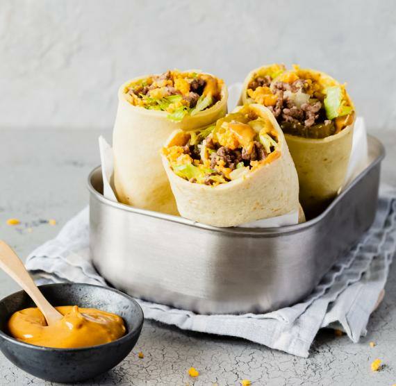 3 kleine Wraps mit Hack und Cheddar, deneben Schälchen mit Sauce