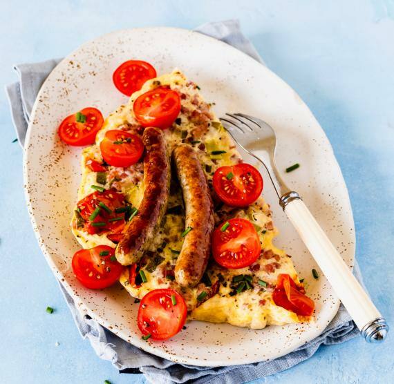 Teller mit Omelett, Tomaten, Würstchen und Petersilie