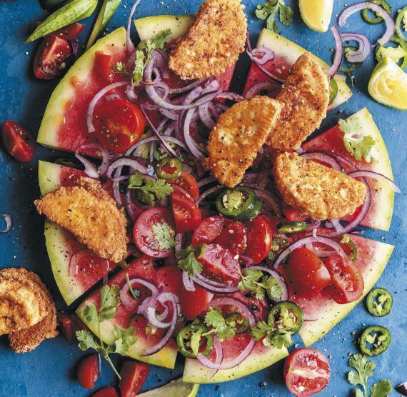 Aufgeschnittene Wassermelonenscheibe mit Käsestücken und Salat