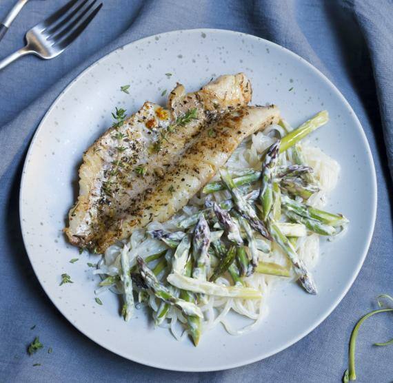 Grünes Spargel und Nudeln mit Fisch auf einem Teller