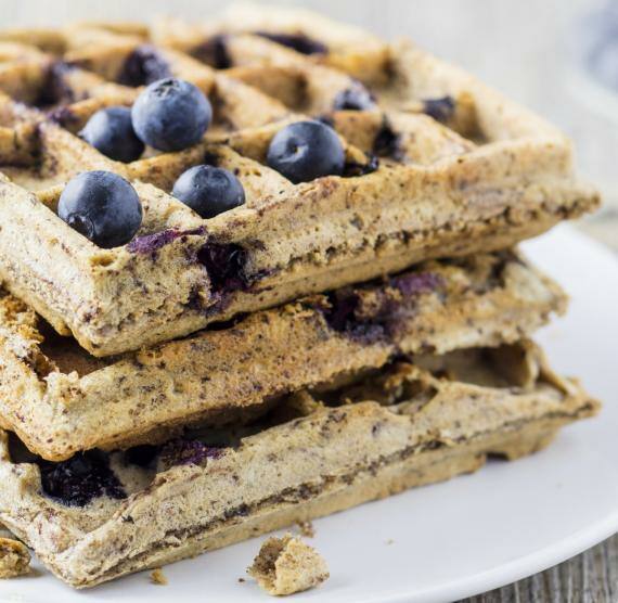 3 gestapelte Waffeln auf weißem Teller, darüber Blaubeeren