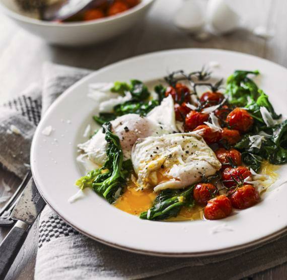 Teller mit pochiertem Ei, Ofentomaten und Spinat