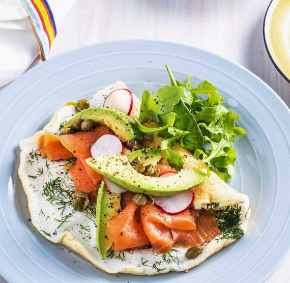 Teller mit Omelett, darauf Räucherlachs, Avocado, Salat und Radieschen