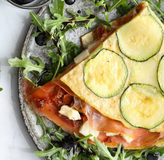 Viertel Omelett mit Zucchini, Parmaschinken, Mozzarella, Rucola und Balsamico