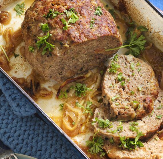 Hackbraten in einem Bräter auf geschmorten Zwiebeln