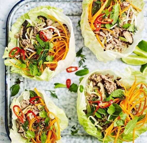 Vier Salatwraps gefüllt mit Karotten Putenfleisch, Karotten, Paprika, Pilzen, Frühlingszwiebeln und Kräutern