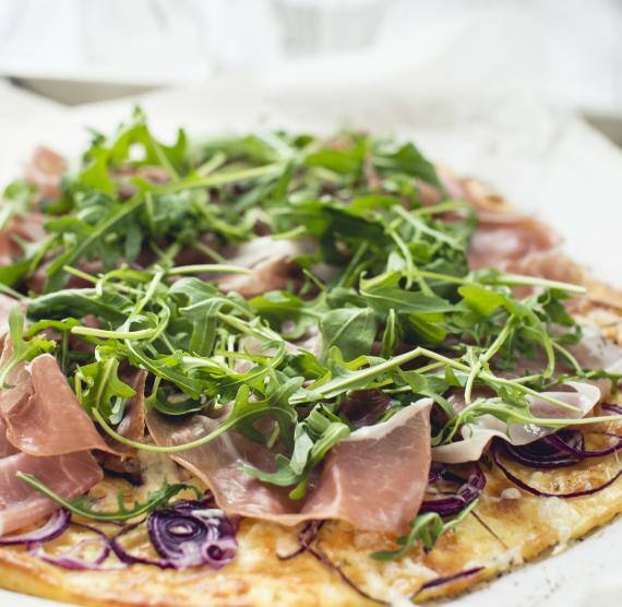 Flammkuchen mit Schinken, roten Zwiebeln und Rucola