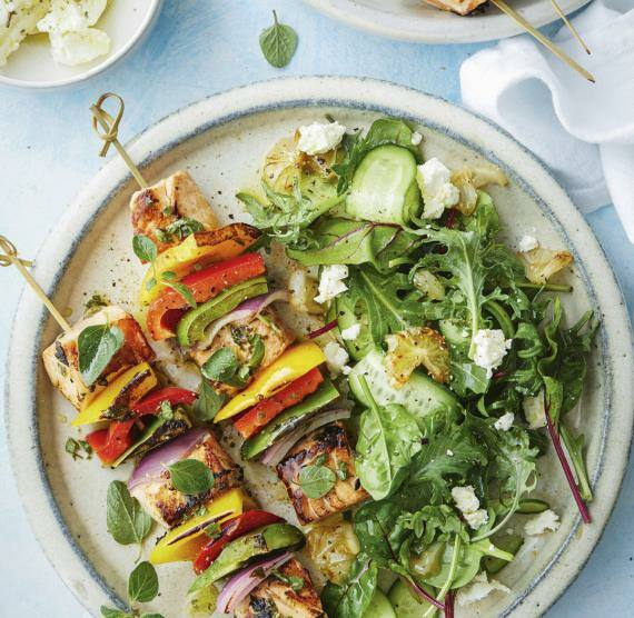 Teller mit Lachsspießen, Salat und gegrillten Zitronen