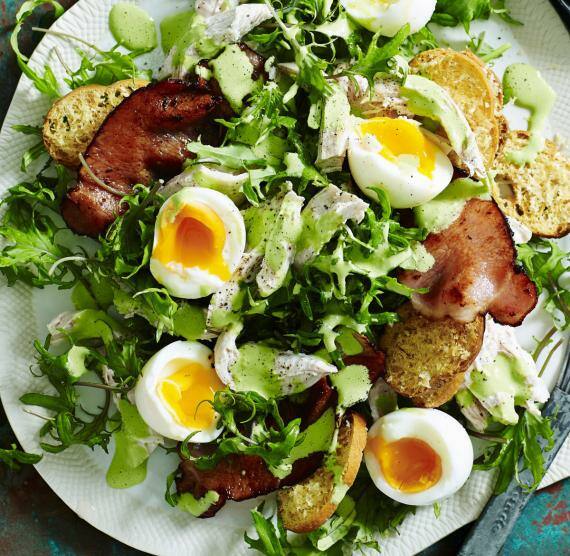 Salat mit Ei, Bacon und Brot auf Teller