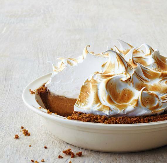 Süßkartoffel-Kürbis-Torte mit Baiserhaube auf hellem Untergrund