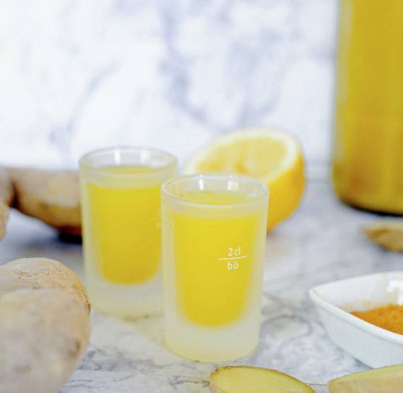 Ingwer-Kurkuma-Shot mit Zitrone in einem Shotglas
