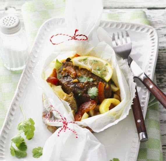 Ingwer-Filetsteak in Pergamentpapier auf einem weißen Teller